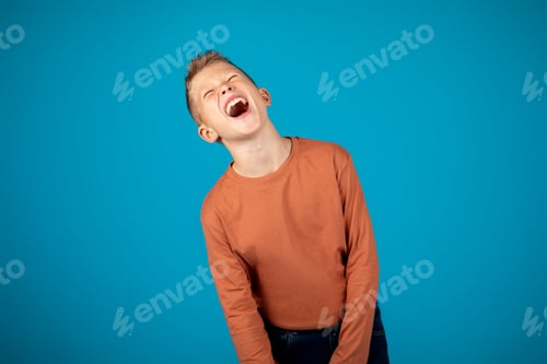 Preview: Tween Mood Swings. Upset Preteen Boy Screaming Over Blue Background