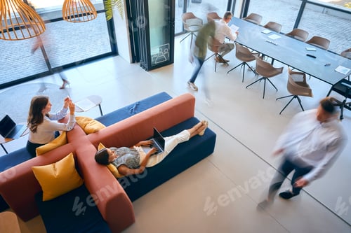 Preview: Overhead View Of Modern Open Plan Office With Staff Working Around Table And Breakout Seating Area