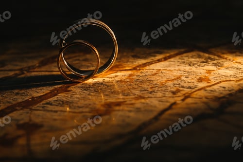 Preview: Couple wedding rings on old marble texture.
