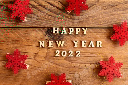 Visualização: feliz ano novo 2022 texto de madeira decorado com flocos de neve de madeira vermelhos. Fundo festivo de ano novo.