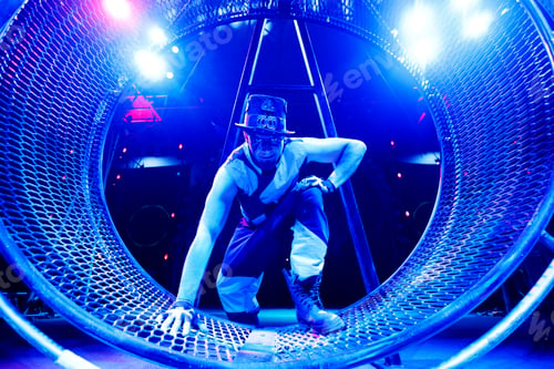 Preview: A clown, a magician entertains guests in the circus arena in the rays of colorful spotlights.