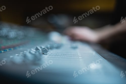 Preview: Blurred shot of a person working on a soundboard