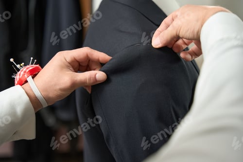 Preview: Tailor Adjusting a Dark Suit with a Pin