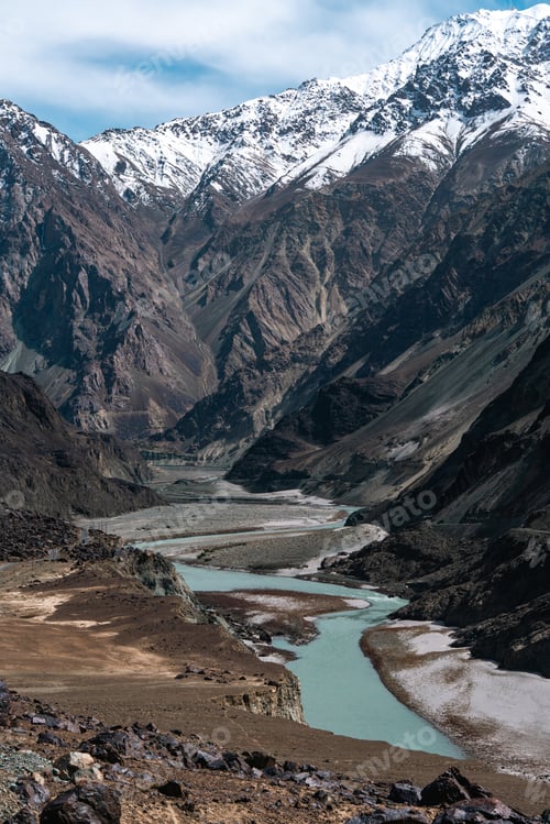 Preview: Serene turquoise river carving through the rugged Himalayan mountainscape, dramatic terrain
