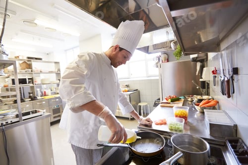 Preview: happy male chef cooking food at restaurant kitchen