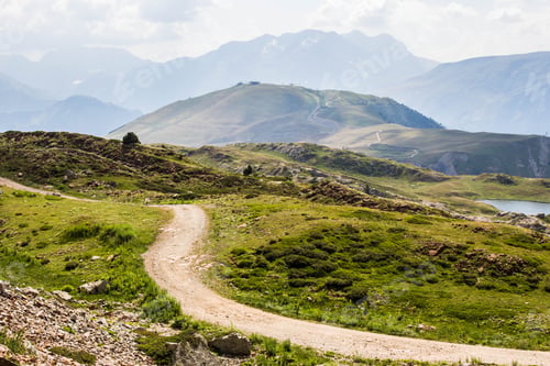 Preview: Aerial shot of a beautiful green trail with the french alps on the background