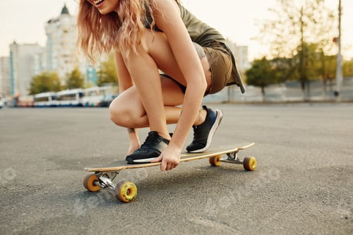 Preview: Beautiful young girl with tattoos sits on longboard