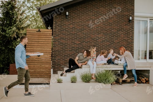 Preview: Group of young people and kids preparing for eating pizza in the house backyard