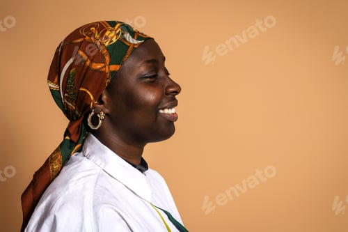 Preview: Laughing black woman in stylish headscarf in studio