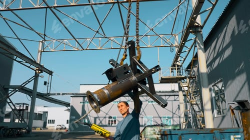 Preview: Crane operator transporting a large metal detail at a steel factory. Creative. Concept of heavy