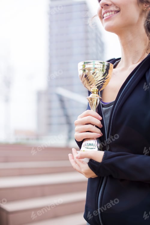 Preview: Sport woman holding a trophy