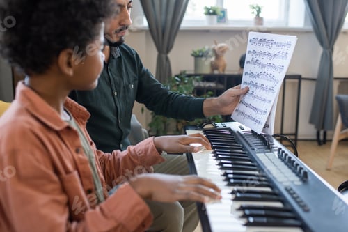 Preview: Teacher of music showing little schoolboy paper with notes
