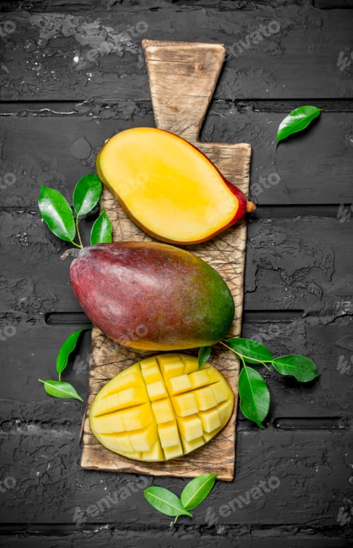 Preview: Whole and pieces of mango on the cutting Board.