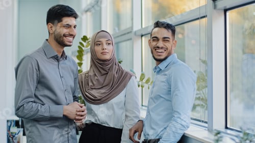 Preview: Smiling millennial multiracial employees talking gossips during break in office, young diverse