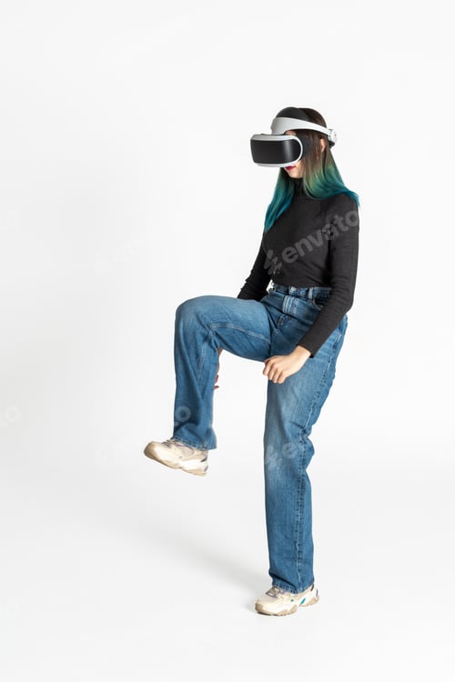 Preview: A teenage girl wearing virtual reality glasses playing video games lifts her leg up