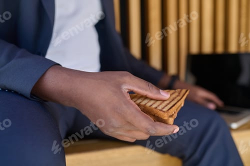 Preview: A man sitting on the bench and having lunch during the break