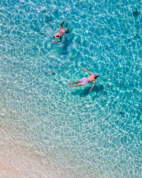 Preview: drone view at a men and woman swimming in the blue turqouse colored ocean of Koh Kradan island