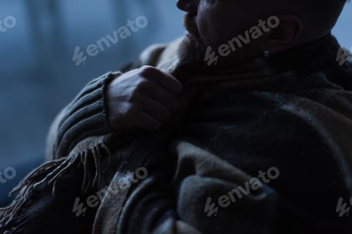 Preview: partial view of man wrapped in warm blanket sitting at home during energy blackout
