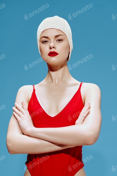 Preview: A confident swimmer in a retro style beanie red swimsuit crossing her arms looks at the camera