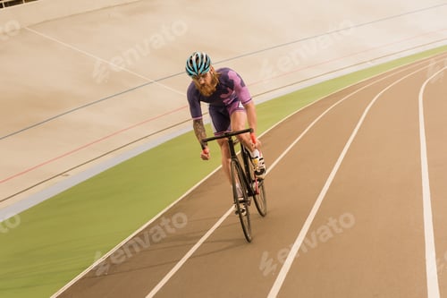 Preview: young cyclist in helmet training on cycle race track
