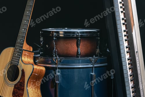 Preview: Acoustic guitar, drums and keys on a black background.