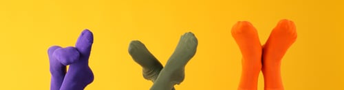 Preview: Legs in different socks on yellow background