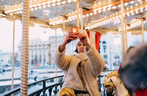 Preview: Content woman on illuminated carousel taking shot