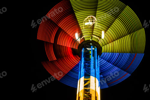 Preview: Neon lights of spinning carousel with dark sky background