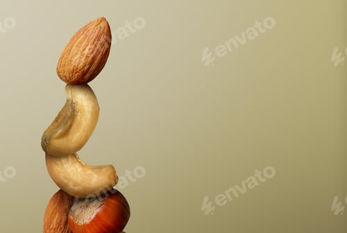 Preview: Stacked different nuts on light brown gradient background, space for text