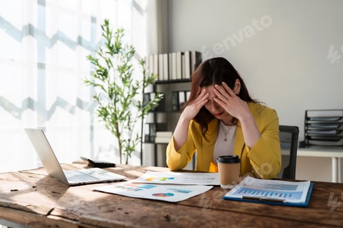 Preview: Stressed businesswoman suffering headache working with financial documents