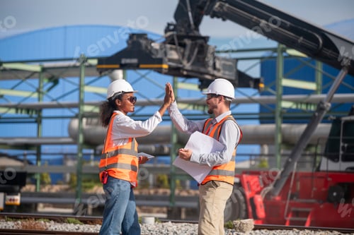 Preview: Engineers railway survey wearing safety uniform and helmet under conversation document on hand inspe
