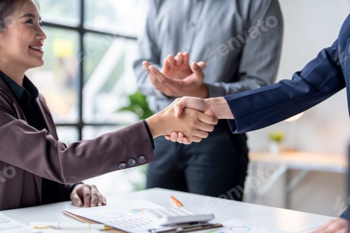 Preview: Businesswomen shaking hands while manager is clapping in the background