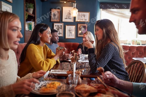 Preview: Group Of People Eating In Restaurant Of Busy Traditional English Pub