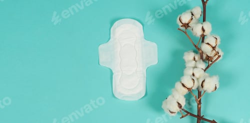 Preview: Sanitary napkin with wings and cotton flowers on mint green or Tiffany Blue background.top view