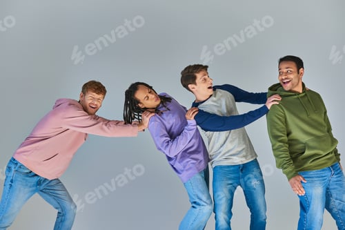 Preview: four smiling happy men in casual urban outfit having great time on grey backdrop, cultural diversity