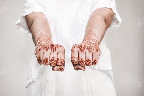 Preview: Woman in white dress with henna tattoo on fists
