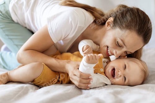 Vista previa: Feliz unión entre una joven madre y un niño pequeño en la cama