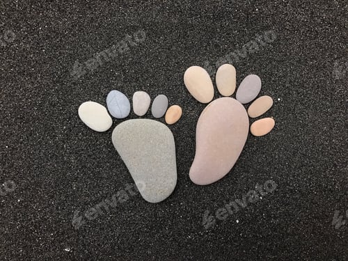 Preview: Feet composed with stones and pebbles over black volcanic sand
