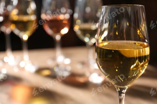 Preview: Tasty white wine in glass against blurred background, space for text