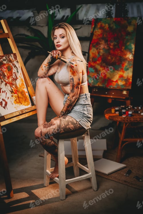 Preview: Stylish blond haired woman sitting on chair in dark room
