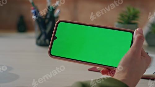 Preview: Woman hands holding chroma key cellphone at workplace close up. Manager watching
