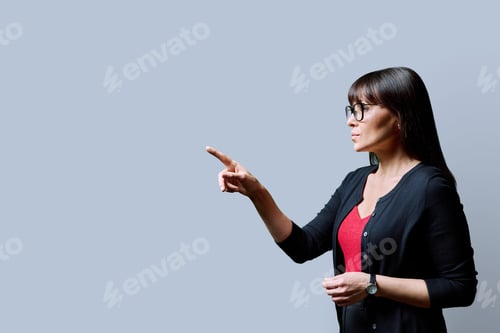 Preview: Profile portrait of mature confident serious woman on grey background