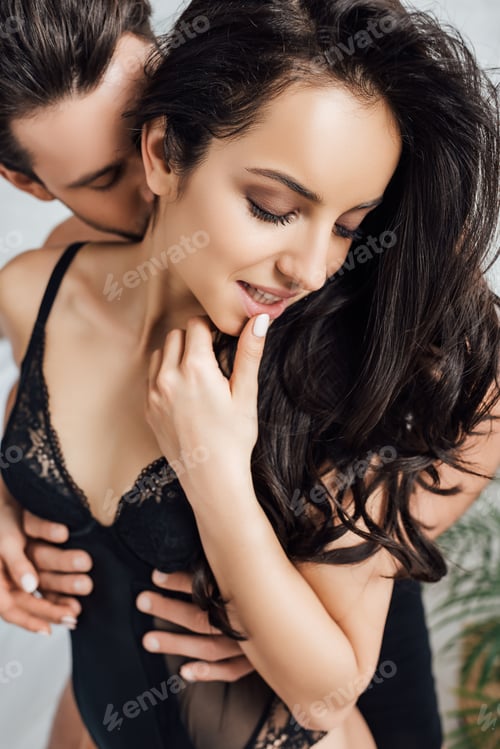 Preview: Selective focus of man hugging and kissing sexy woman with closed eyes