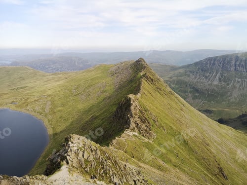 Preview: Striding Edge mountain peak near a lake with a blue sky in the background, Lake District, England