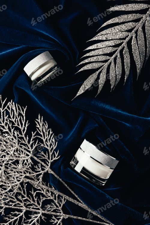 Preview: top view of beauty cream between silver decorated branches on velvet surface