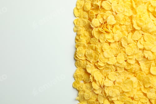Preview: Dry uncooked corn flakes on white background, space for text