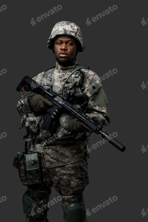 Preview: Armed black soldier with rifle looking at camera