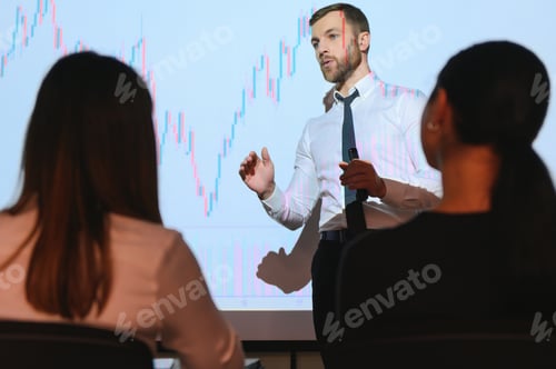 Preview: Young Businessman Explaining Graphs To His Colleagues On Projector