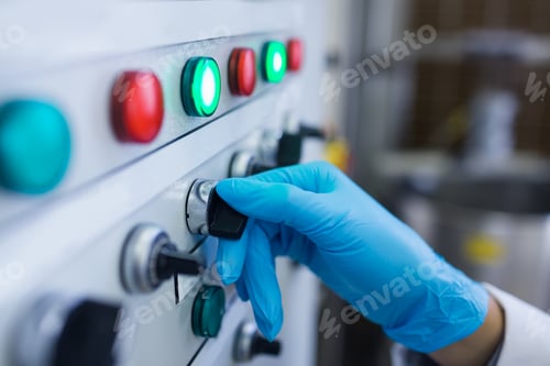 Preview: Hand with gloves turning buttons of the machine in the factory