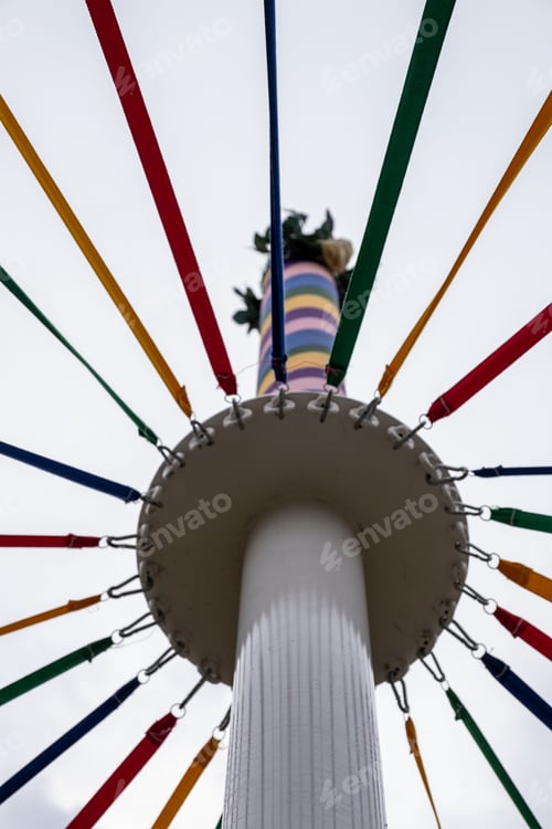 Preview: Low angle shot of a classic English Maypole during a dancing festival under a cloudy sky